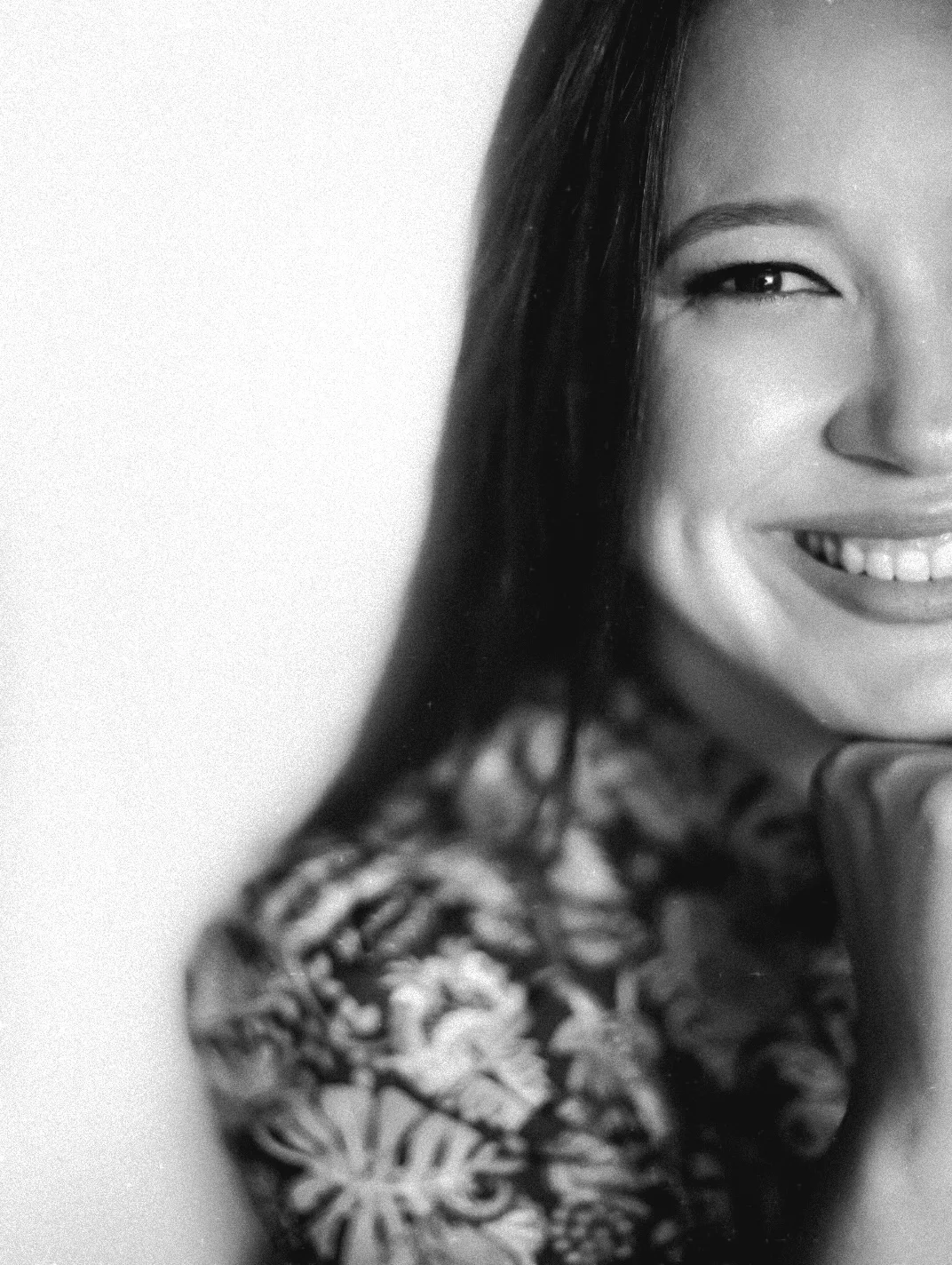 Detalhe do rosto de uma mulher sorrindo, em preto e branco