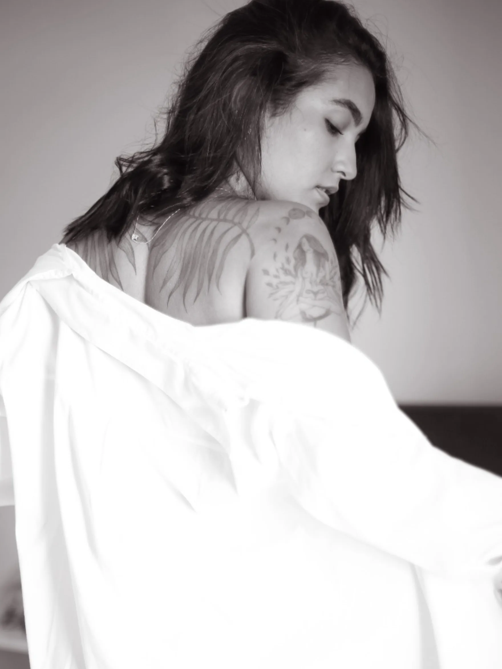 Mulher com tecido branco junto aos ombros, em preto e branco