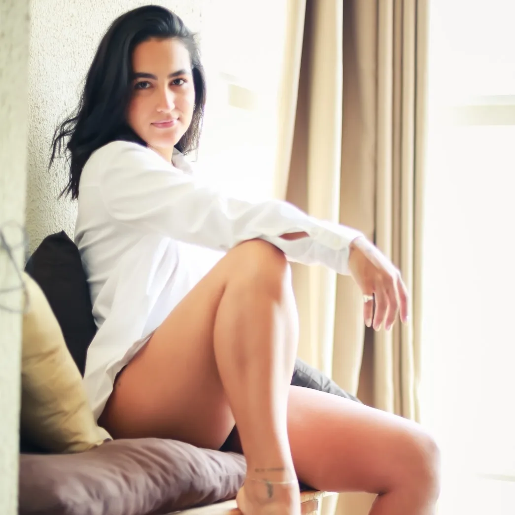 Mulher sentada no sofá com camisa branca