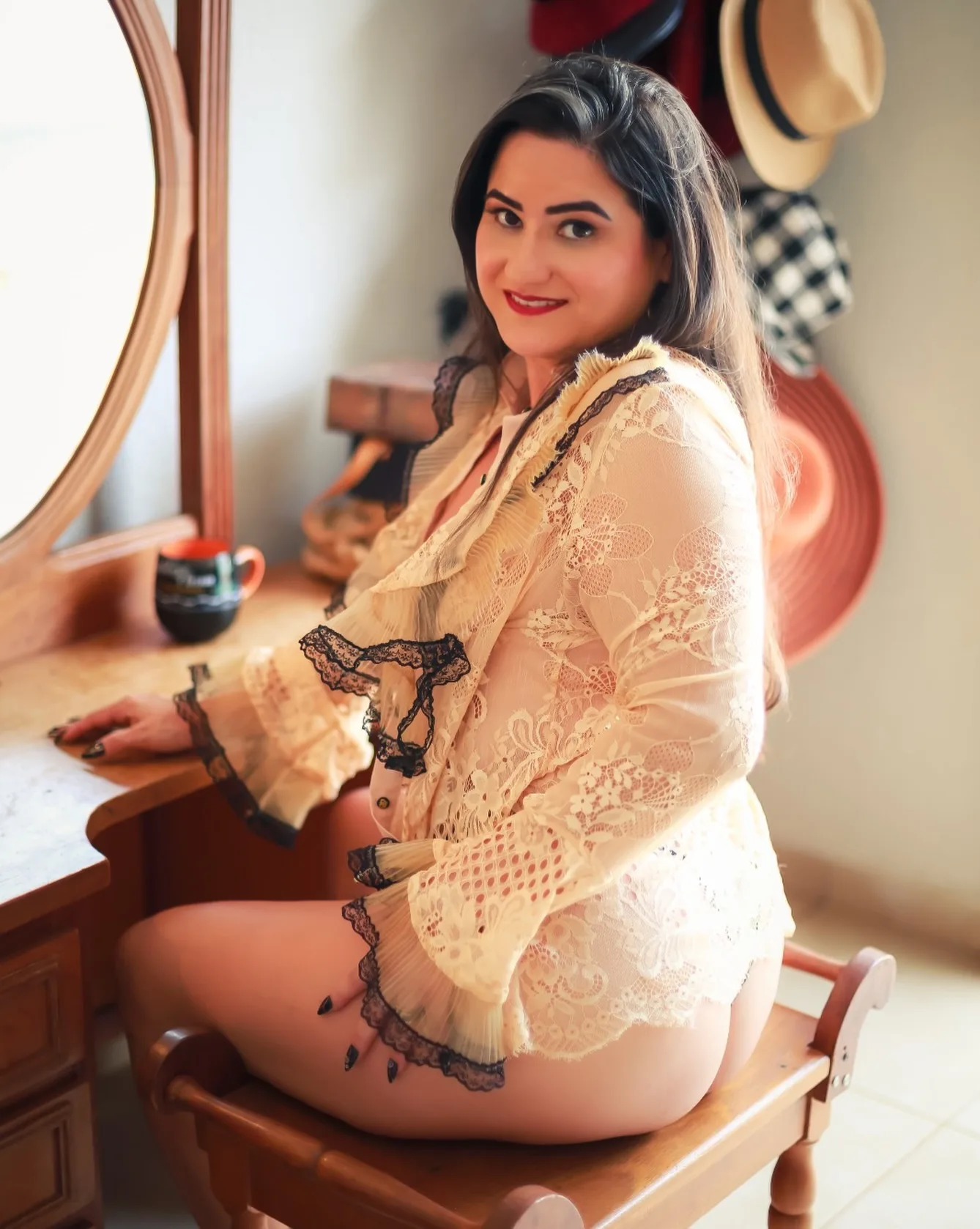 Mulher sentada com robe de renda clara em um ambiente interno