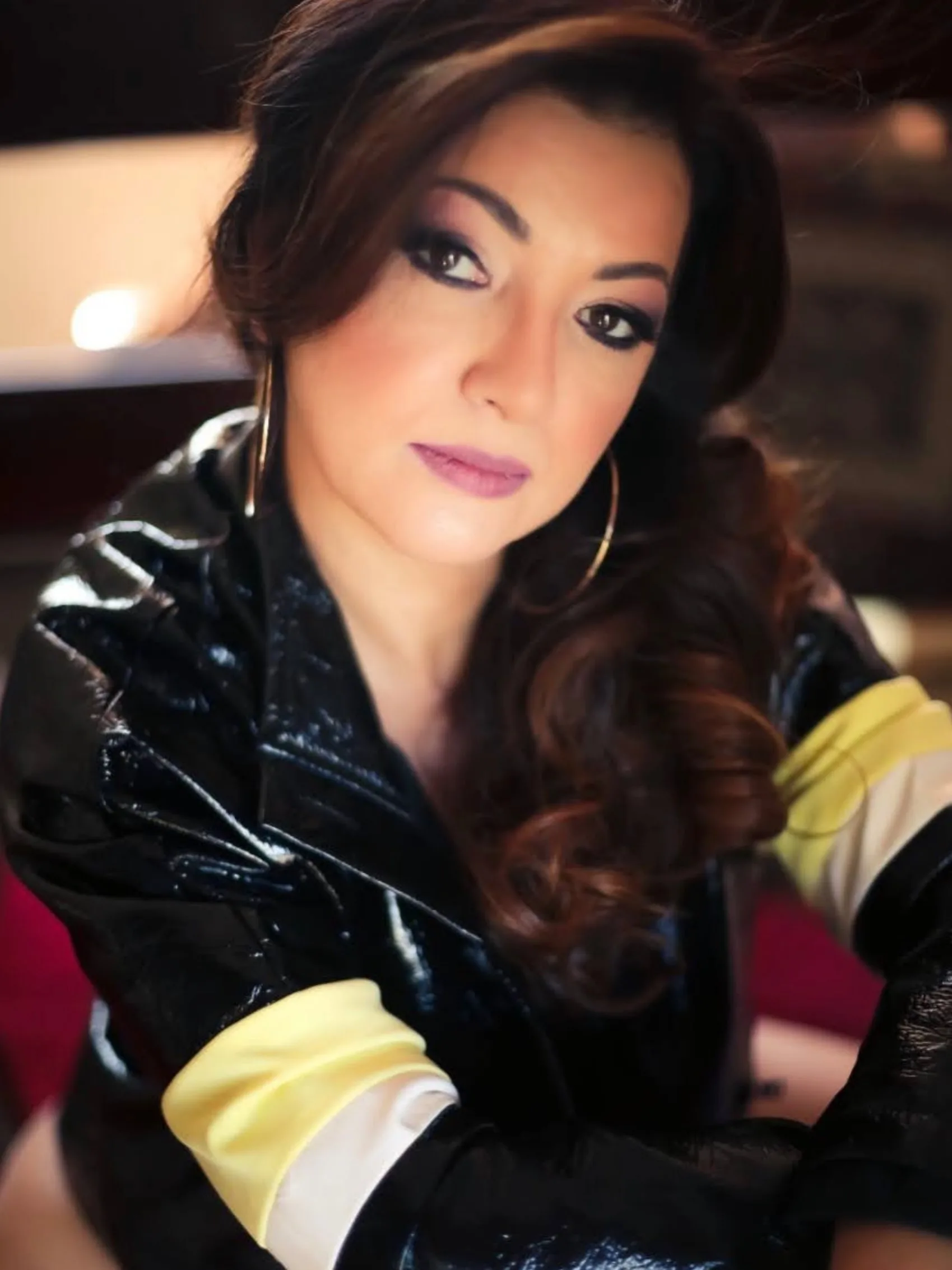Retrato de mulher com roupa preta e detalhe dourado