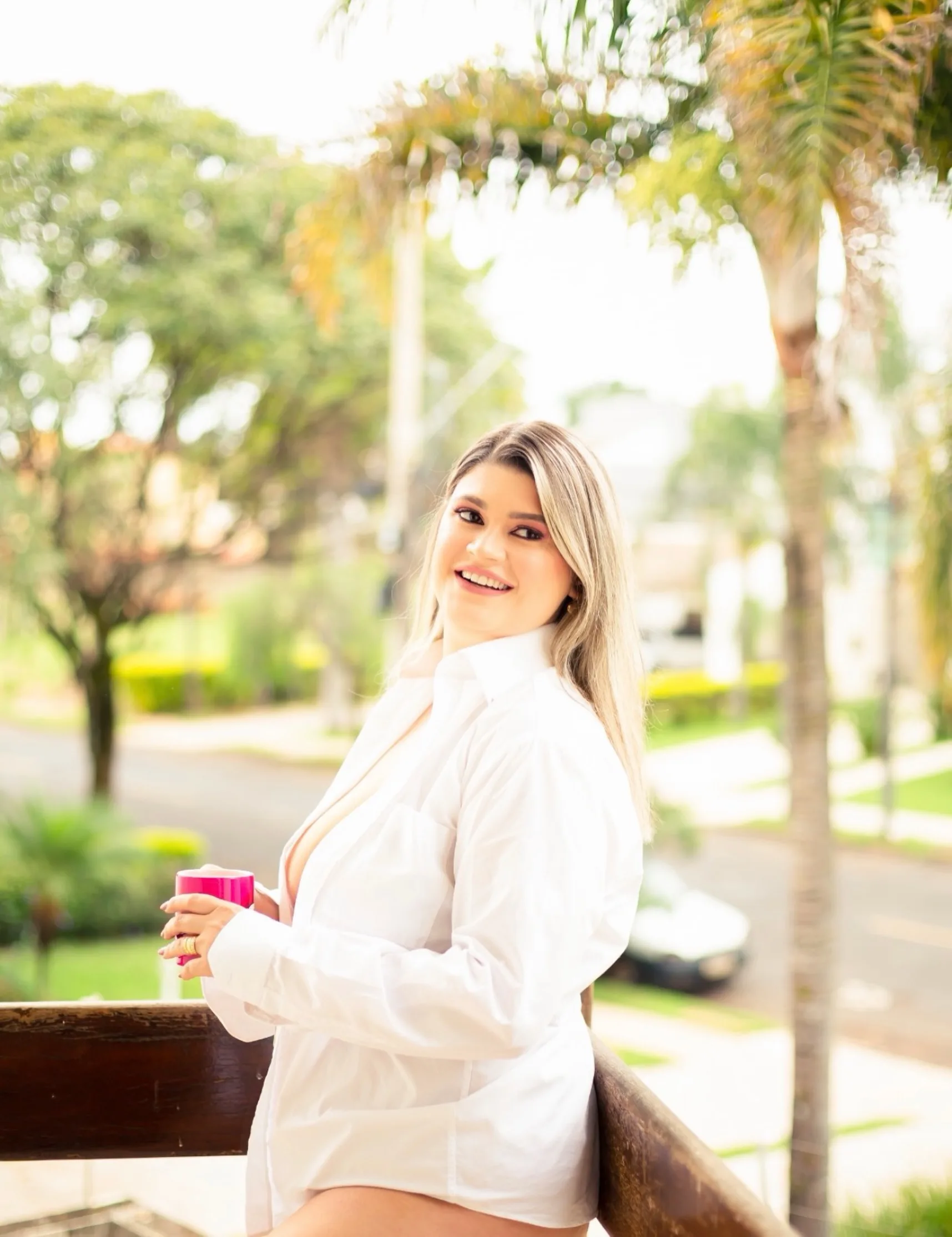 Mulher olhando sobre o ombro com camisa branca, ao ar livre