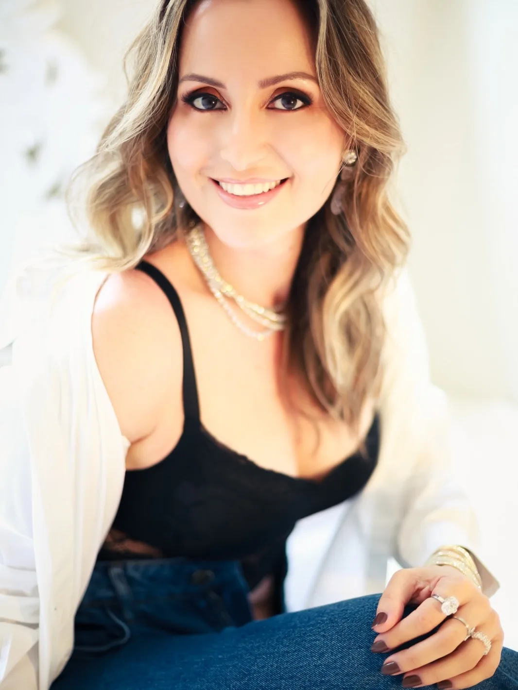 Retrato de mulher sorrindo com camisa branca e peça preta